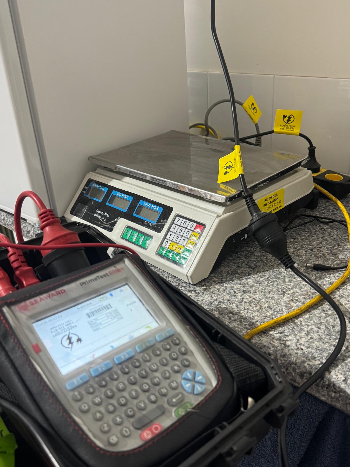 Qualified technician testing and tagging electrical tools with digital testing meter